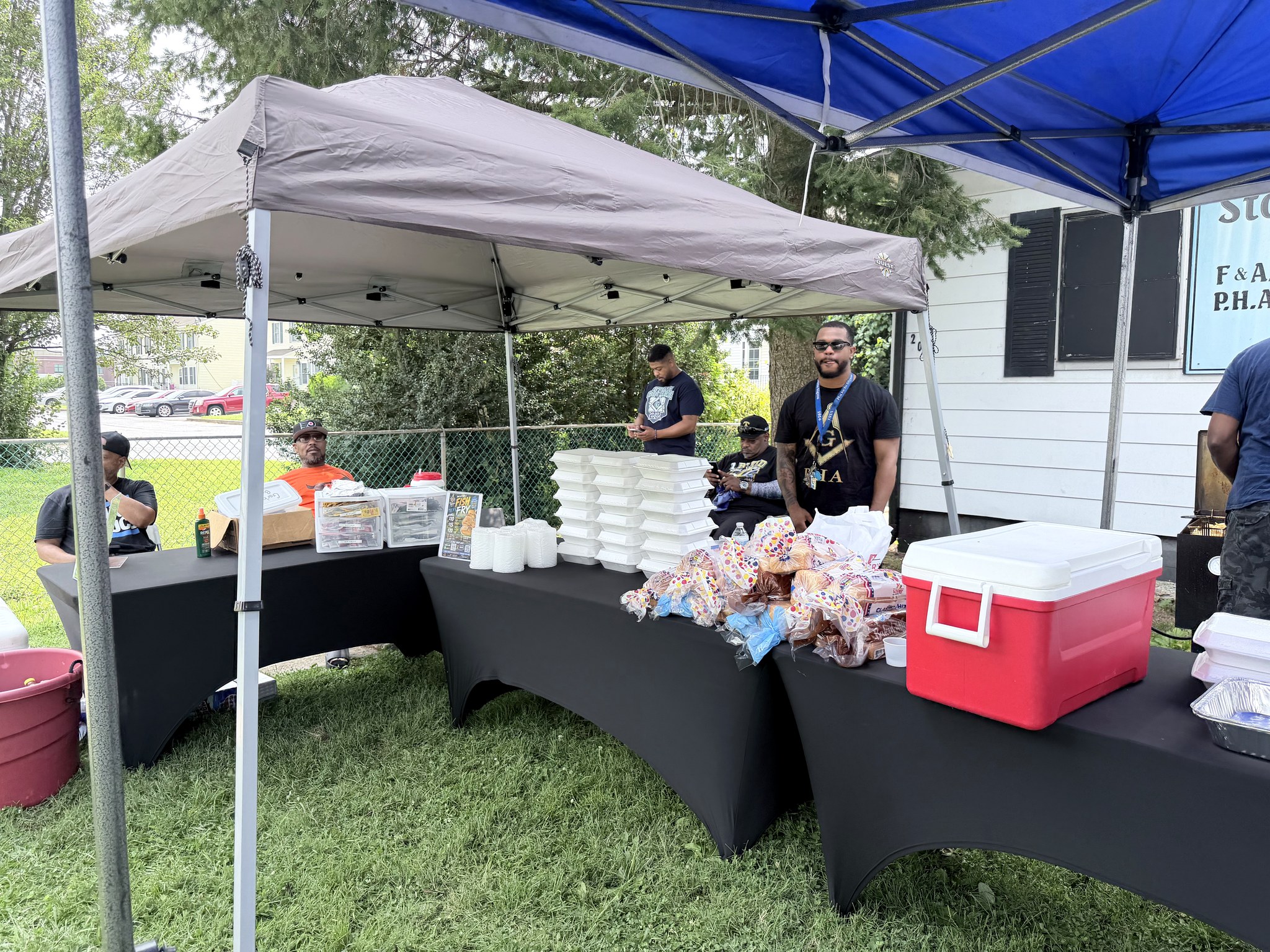 Brothers gathered around the food tables outside Stone Square Lodge at the MOT Camp Fish Fry